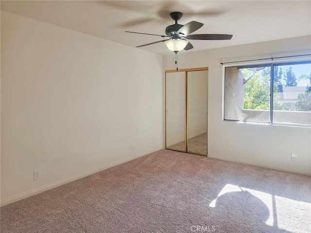 unfurnished bedroom with carpet flooring, ceiling fan, and a closet