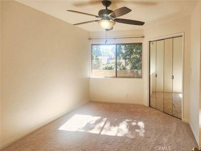 unfurnished bedroom with light carpet, a closet, and ceiling fan