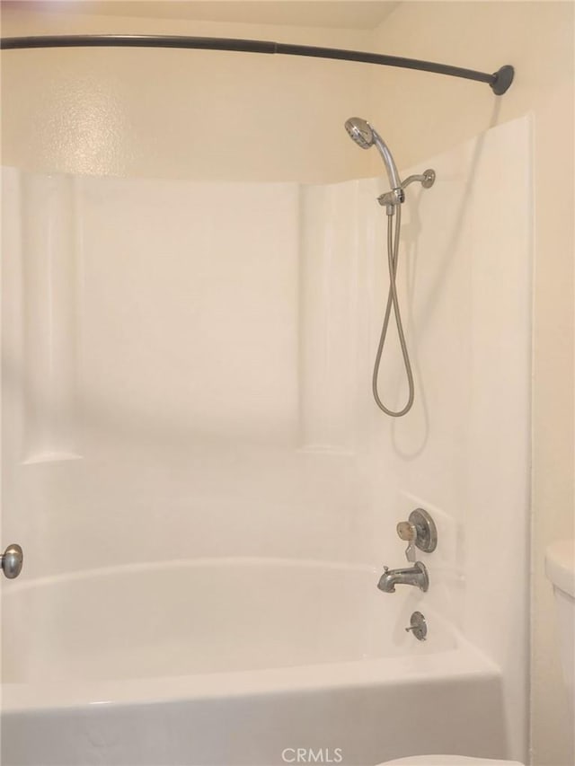 bathroom with shower / bathtub combination and toilet