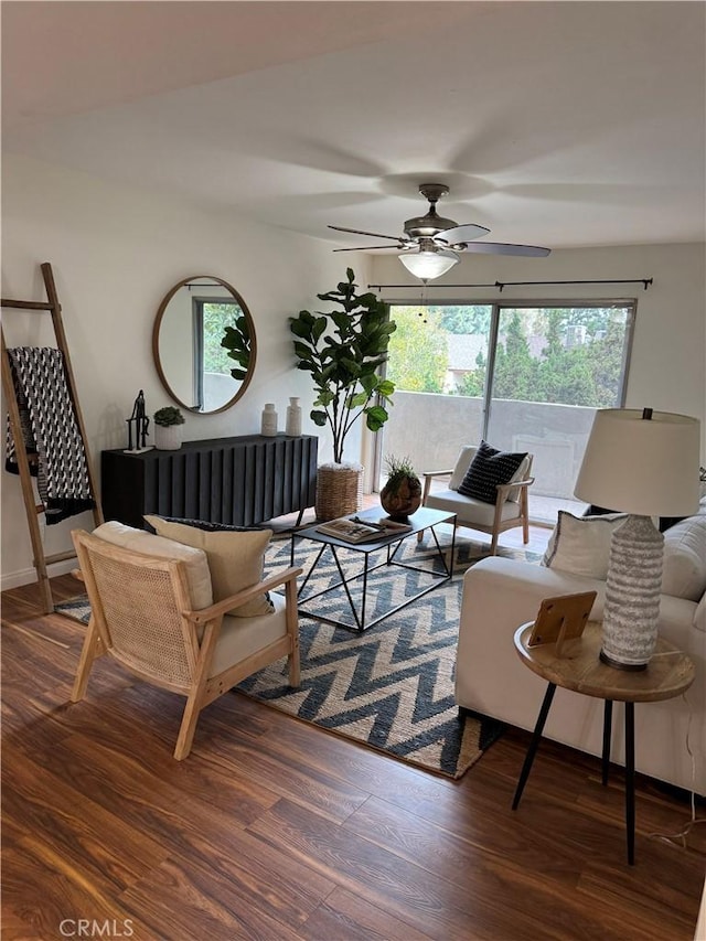 living room featuring ceiling fan and dark hardwood / wood-style flooring