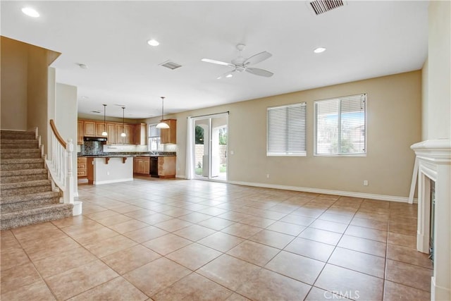 unfurnished living room featuring light tile patterned floors and ceiling fan