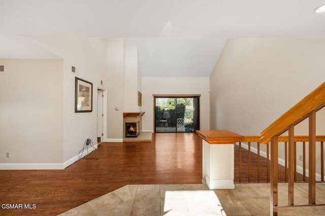 interior space with hardwood / wood-style flooring and high vaulted ceiling