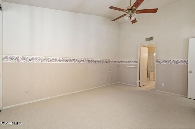 empty room featuring light carpet, vaulted ceiling, and ceiling fan