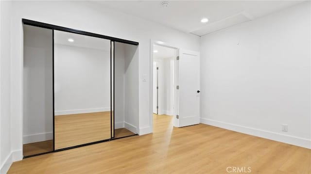 unfurnished bedroom with a closet and light hardwood / wood-style floors