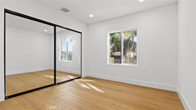 unfurnished bedroom with a closet and hardwood / wood-style floors