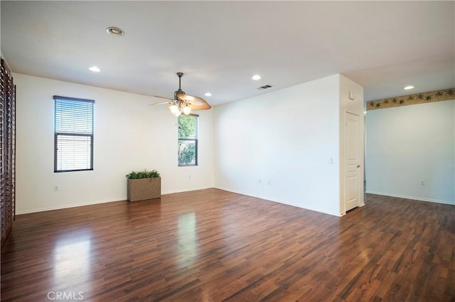 spare room featuring dark wood-type flooring and ceiling fan