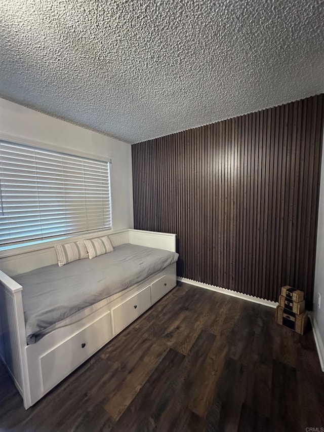 unfurnished bedroom featuring dark wood-type flooring and a textured ceiling