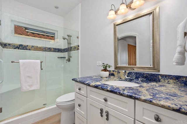 bathroom featuring vanity, toilet, and an enclosed shower