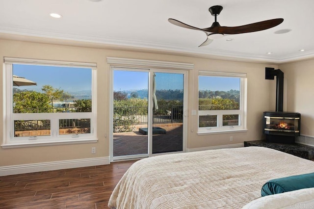 bedroom with access to outside, a wood stove, ceiling fan, and ornamental molding