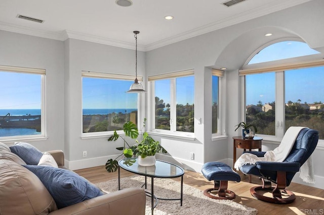 interior space featuring a water view, hardwood / wood-style flooring, and ornamental molding