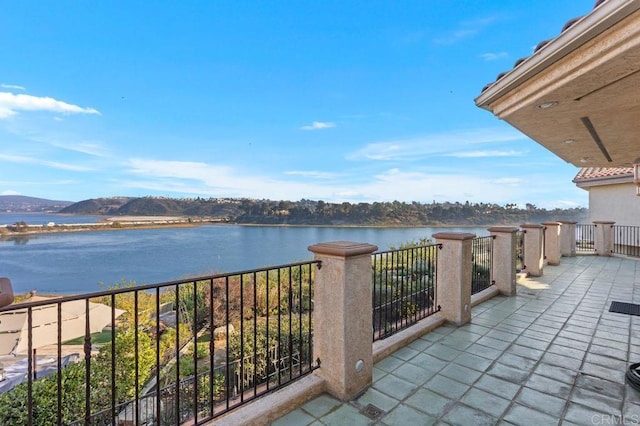 balcony featuring a water and mountain view