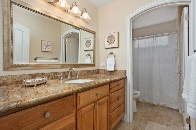 bathroom with vanity, toilet, and curtained shower