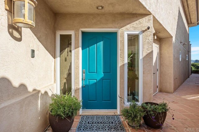 entrance to property featuring stucco siding