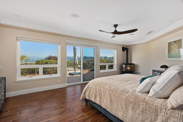 bedroom with ornamental molding, dark wood-type flooring, a wood stove, access to outside, and baseboards