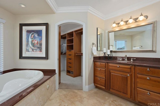 bathroom featuring baseboards, a bathing tub, a spacious closet, crown molding, and vanity