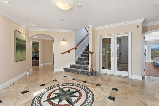 entryway with baseboards, arched walkways, crown molding, and french doors