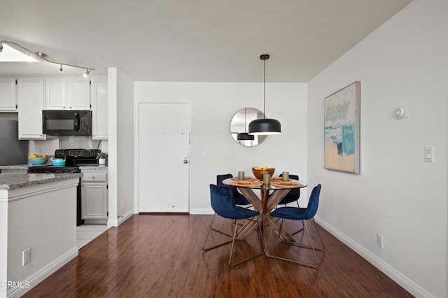 kitchen with black appliances, decorative light fixtures, white cabinets, and hardwood / wood-style floors