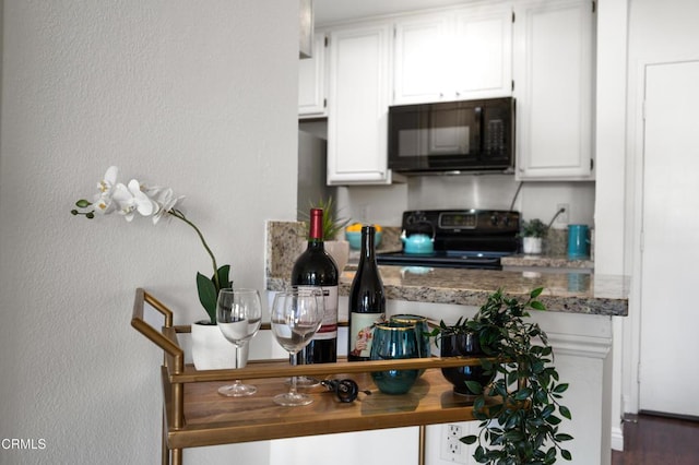 kitchen featuring white cabinetry, dark wood-type flooring, and black appliances