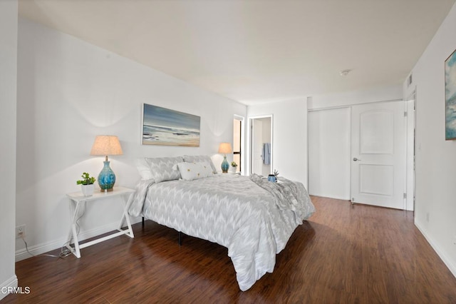 bedroom with dark hardwood / wood-style floors and a closet