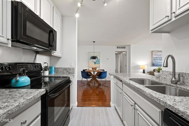 kitchen with white cabinetry, sink, black appliances, and decorative light fixtures