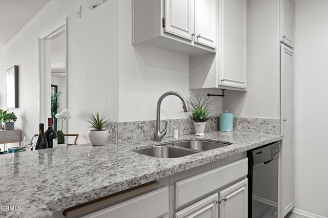 kitchen with white cabinetry, dishwasher, light stone countertops, and sink