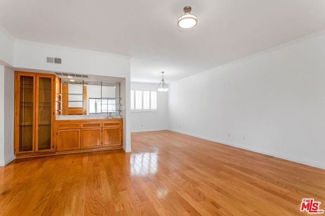 unfurnished living room with light hardwood / wood-style flooring and ornamental molding