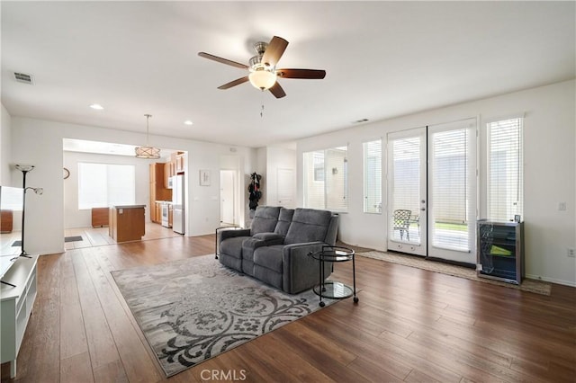 living room featuring ceiling fan and dark wood-type flooring