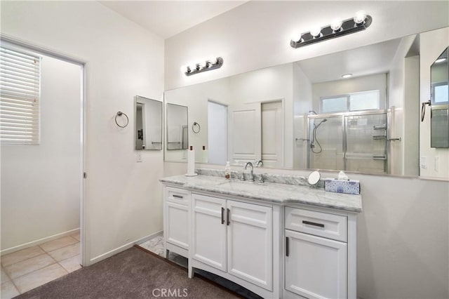 bathroom with tile patterned flooring, vanity, and walk in shower