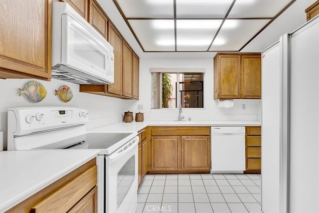 kitchen with light tile patterned flooring, white appliances, and sink