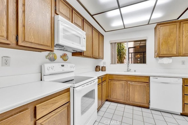 kitchen featuring white appliances, sink, and light tile patterned floors