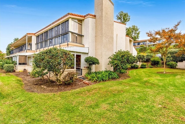 rear view of house featuring a lawn