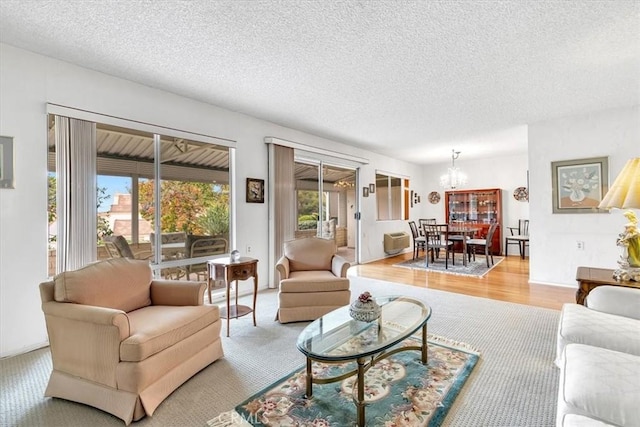 living room featuring light wood-type flooring, a textured ceiling, and a chandelier