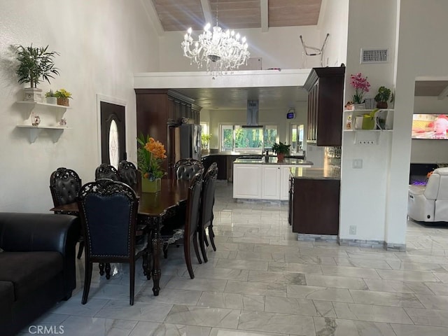 dining room with sink, a notable chandelier, beam ceiling, and wood ceiling