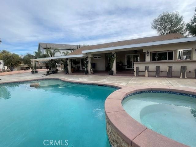 view of swimming pool featuring a patio area and an in ground hot tub