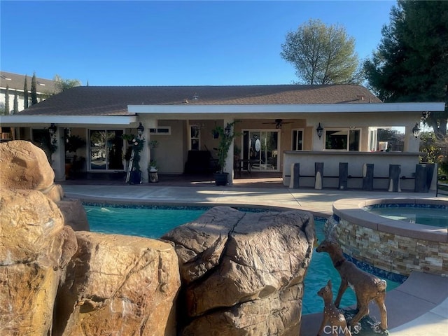 view of pool with ceiling fan, a bar, a patio, and an in ground hot tub