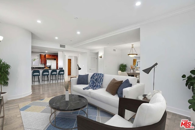 living room with ornamental molding and light wood-type flooring