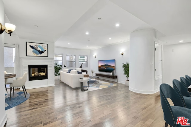 living room featuring hardwood / wood-style flooring and crown molding