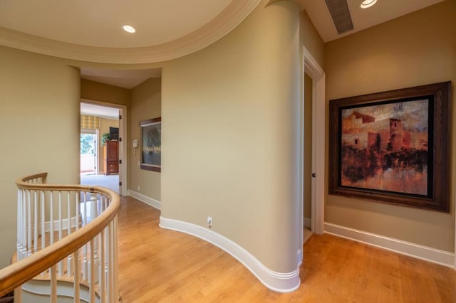 corridor featuring crown molding and light hardwood / wood-style flooring