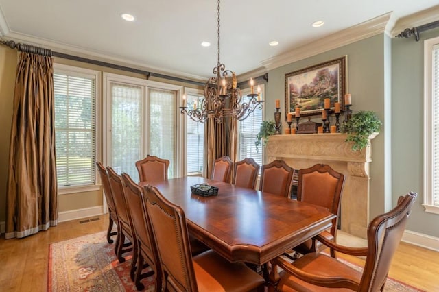 dining area with ornamental molding, light wood-type flooring, and a healthy amount of sunlight