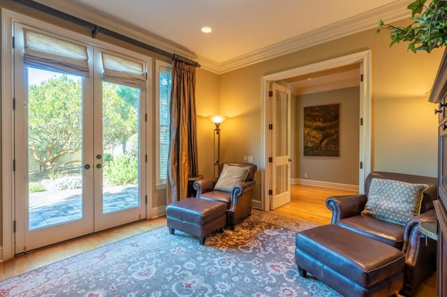 living area featuring french doors, light wood-type flooring, and crown molding