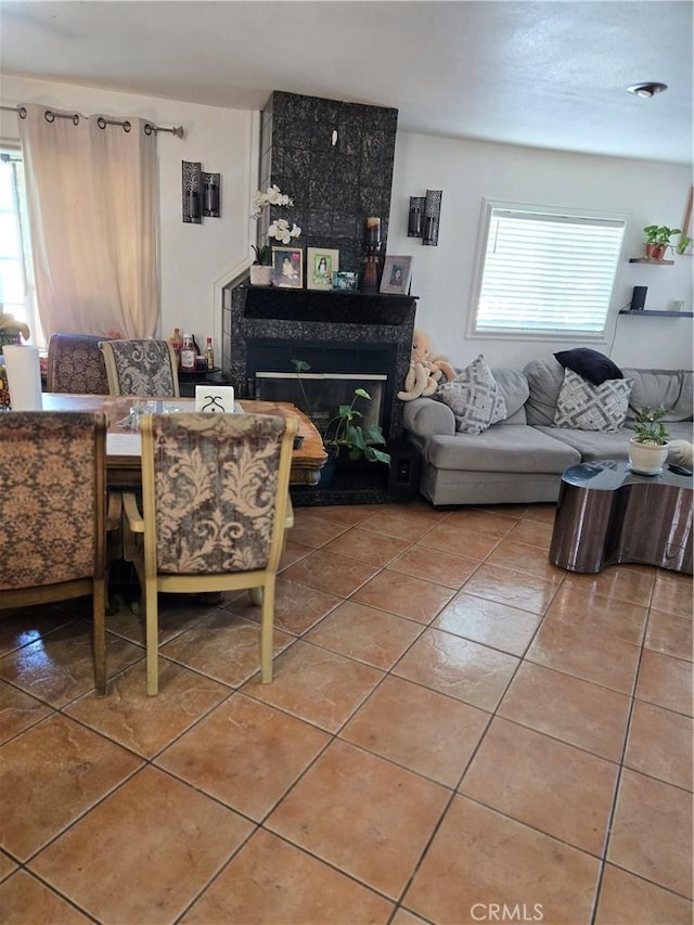 tiled living room with a large fireplace and a healthy amount of sunlight