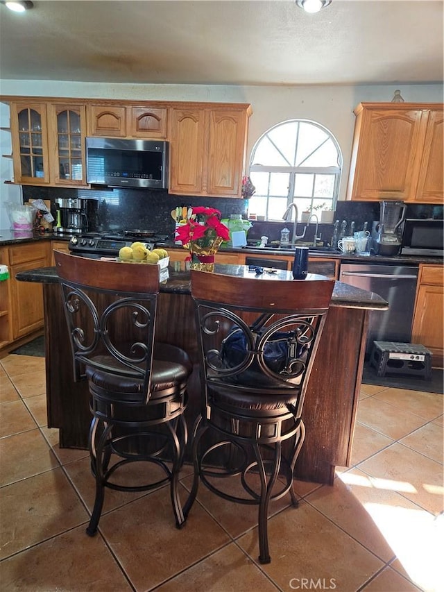 kitchen featuring tasteful backsplash, sink, a center island, and appliances with stainless steel finishes