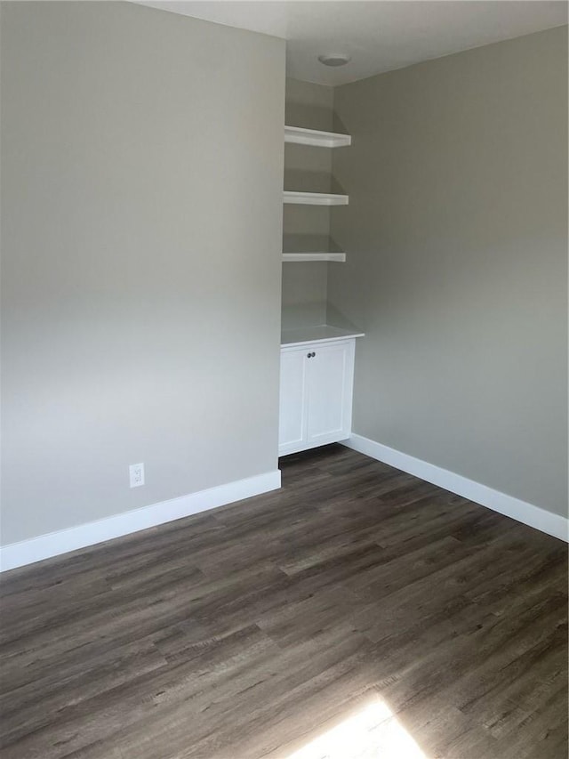 unfurnished room with dark hardwood / wood-style flooring