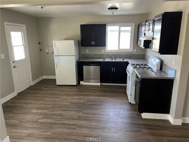 kitchen featuring sink, white appliances, dark wood-type flooring, and stone counters