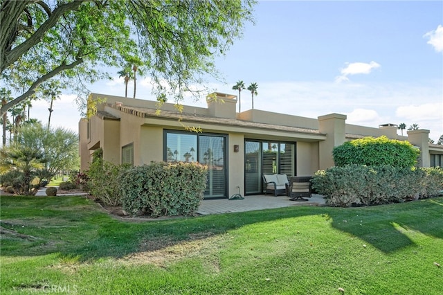 back of house with a lawn and a patio