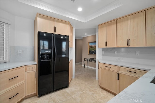 kitchen featuring black fridge and light brown cabinetry