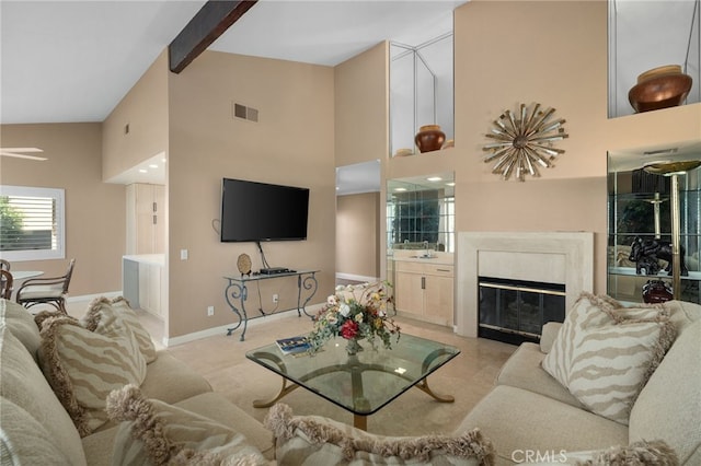 carpeted living room with beam ceiling and high vaulted ceiling