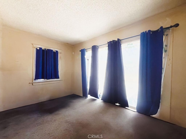 unfurnished room featuring a textured ceiling