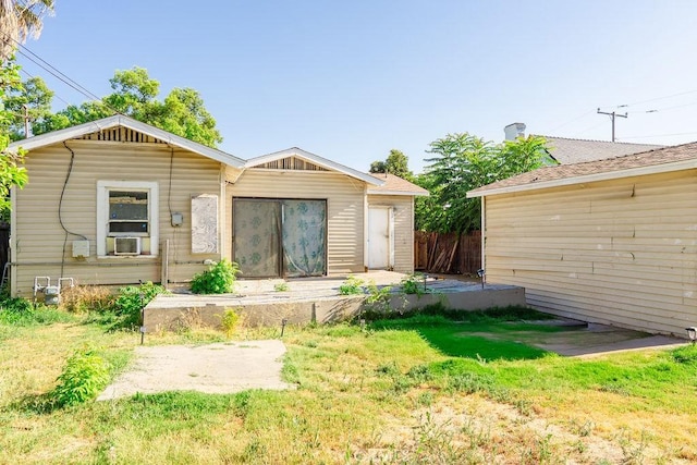 rear view of house with cooling unit and a lawn