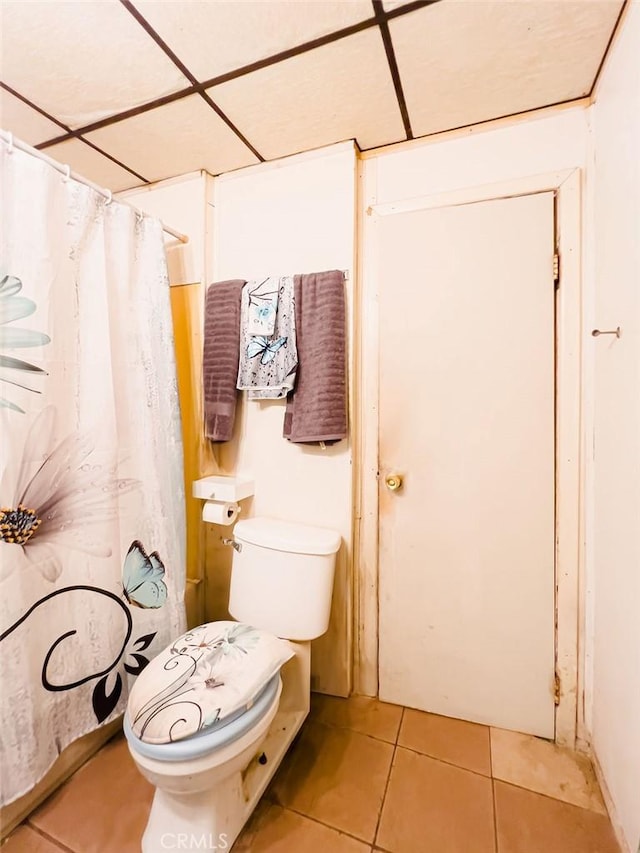 bathroom featuring tile patterned flooring, a paneled ceiling, and toilet